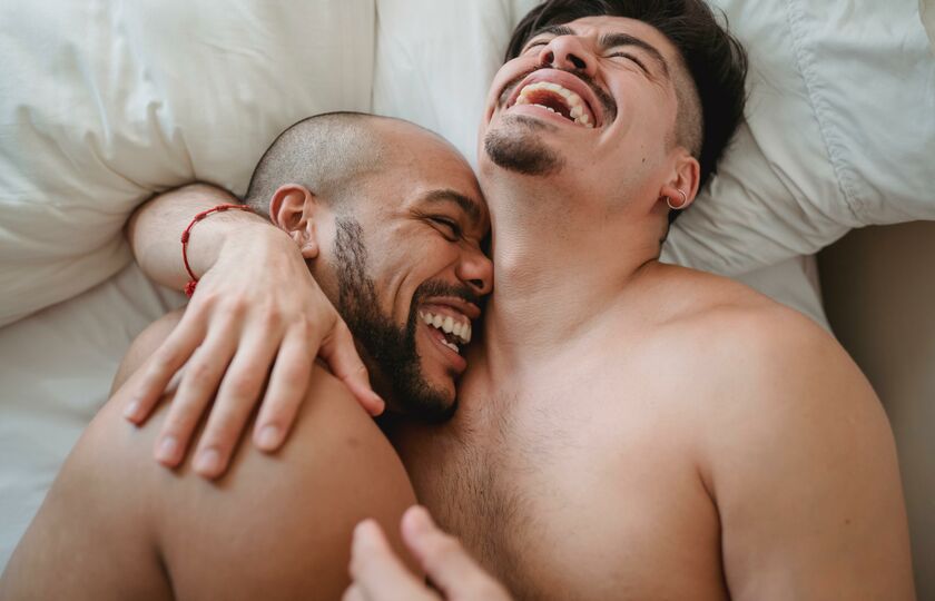 Men laughing bed together