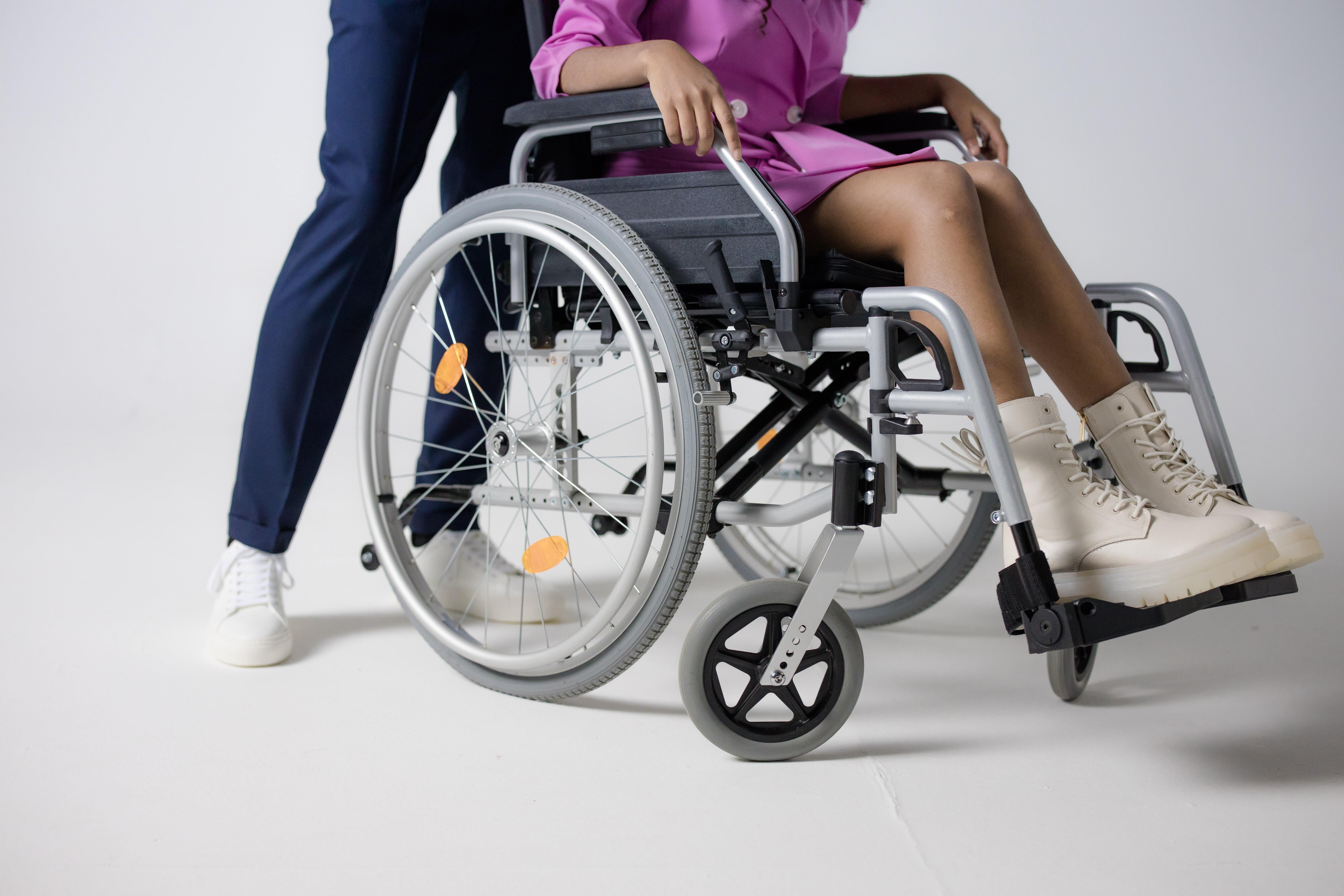 Man pushing woman in wheelchair